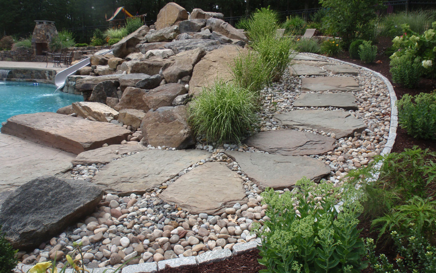 Decorative stepping stone path integrated with surrounding landscape materials